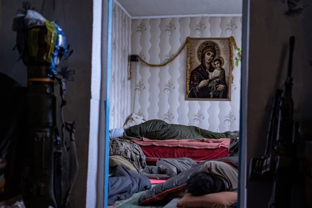 Mężczyźni śpią, dochodząc do siebie po walkach na Ukrainie po inwazji Rosji.